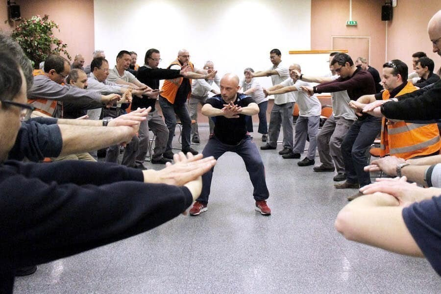 Groupe de personnes faisant des activités physiques dans leur lieu de travail